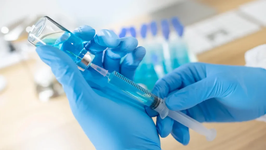 Person filling a syringe.